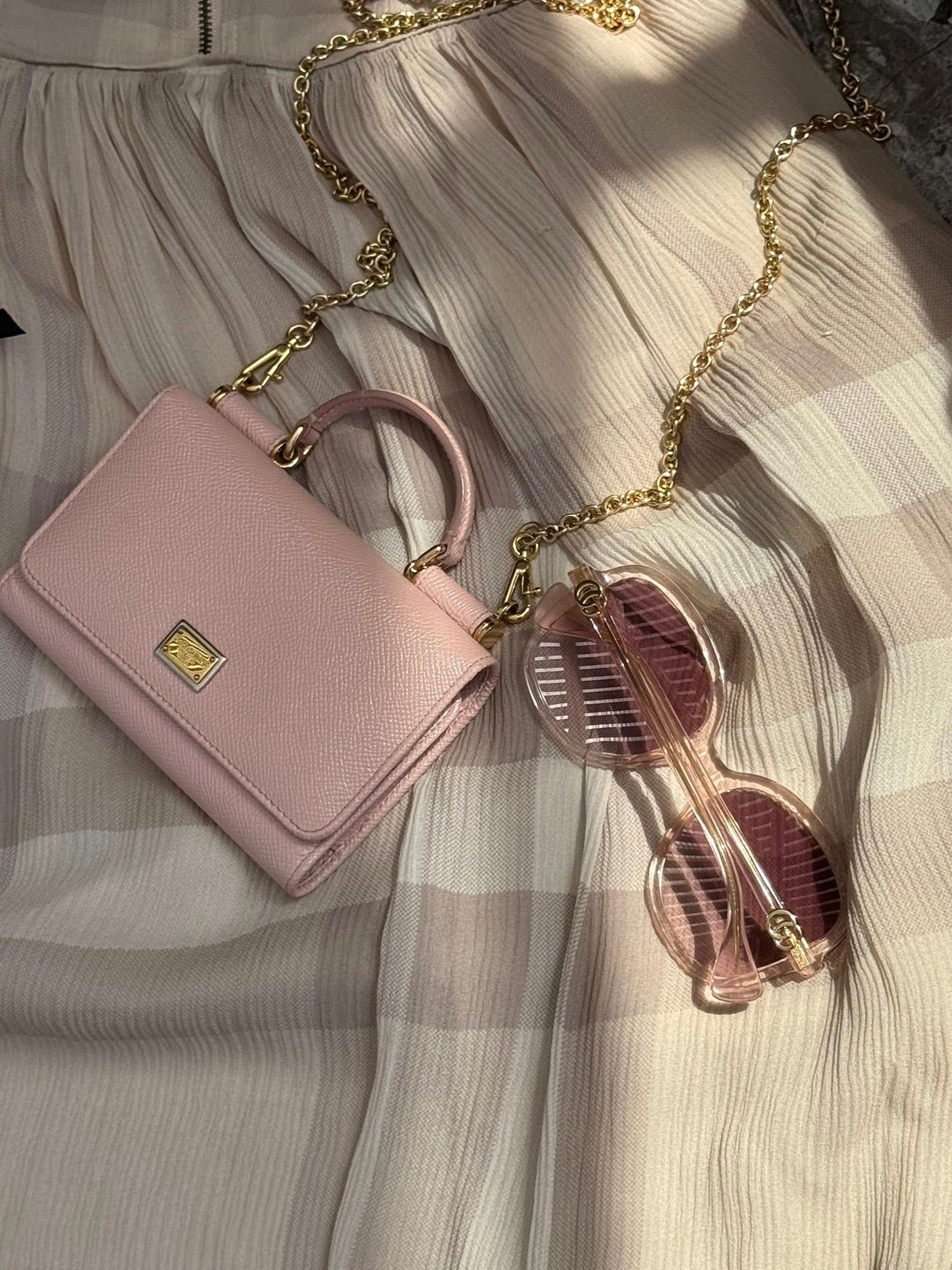 «Кошелёк-сумка Dolce & Gabbana в пудрово-розовом цвете, зернистая кожа, логотип и цепочка — 800 ₪».