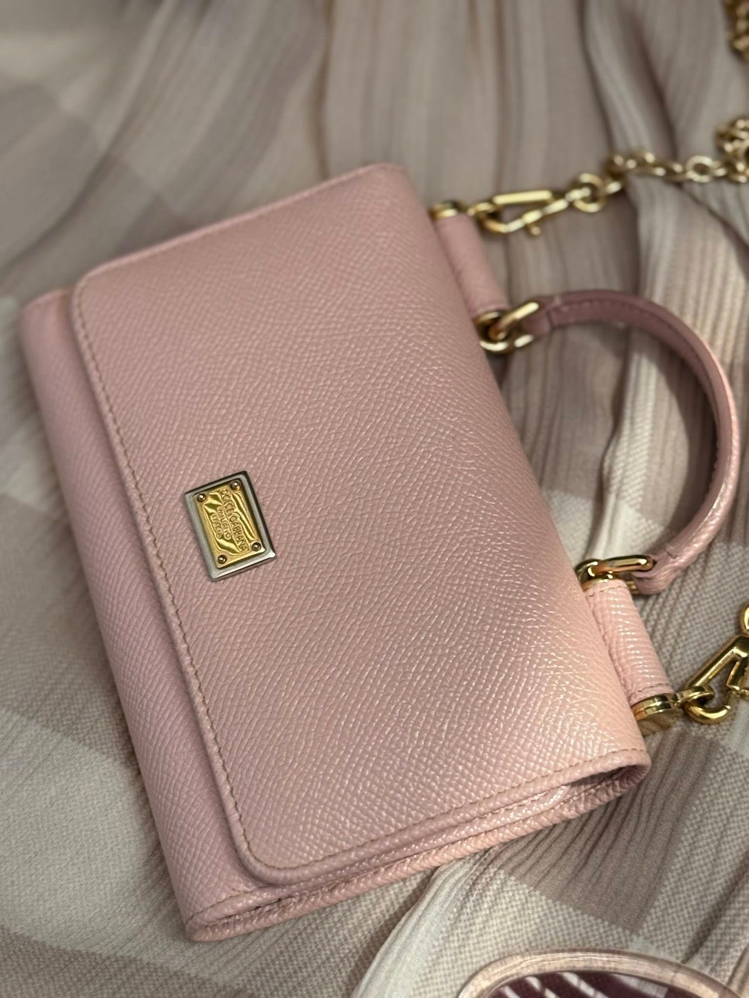 «Кошелёк-сумка Dolce & Gabbana в пудрово-розовом цвете, зернистая кожа, логотип и цепочка — 800 ₪».