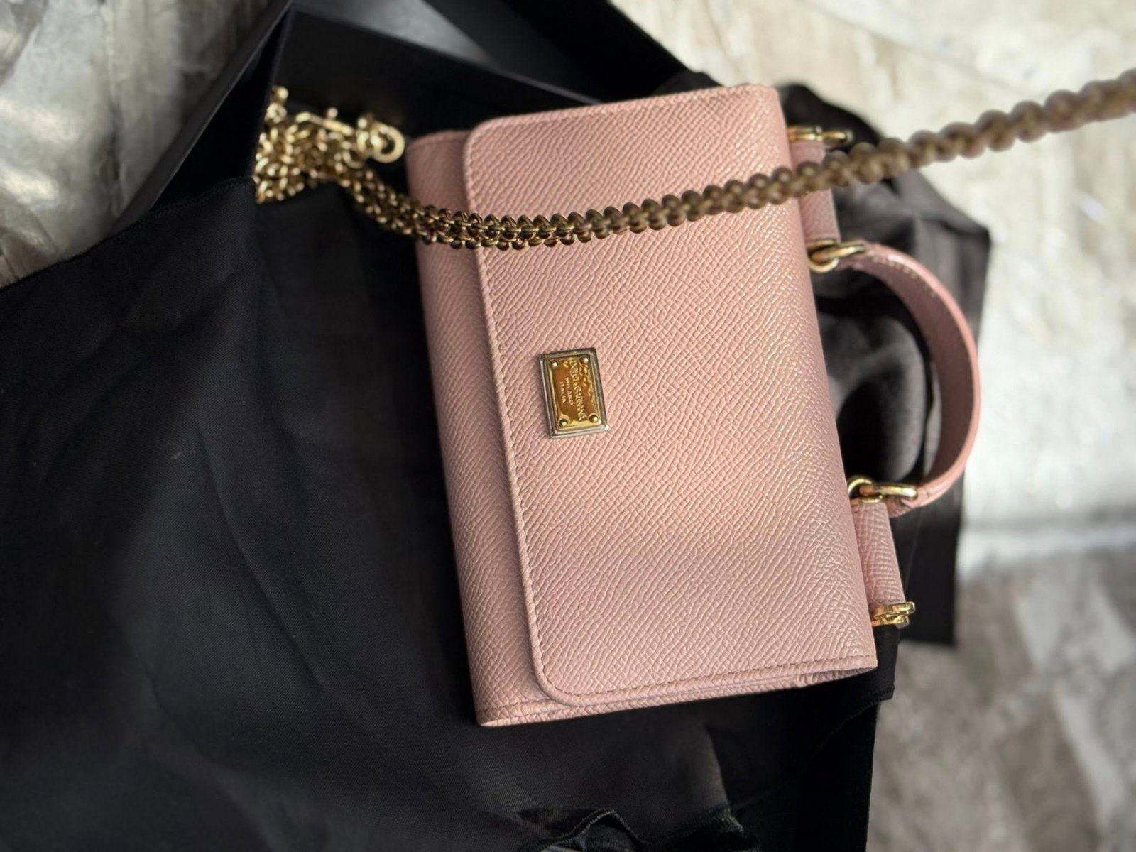 «Кошелёк-сумка Dolce & Gabbana в пудрово-розовом цвете, зернистая кожа, логотип и цепочка — 800 ₪».