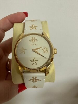 Белые кожаные часы Gucci с золотыми элементами и фирменным узором пчёл и звёзд