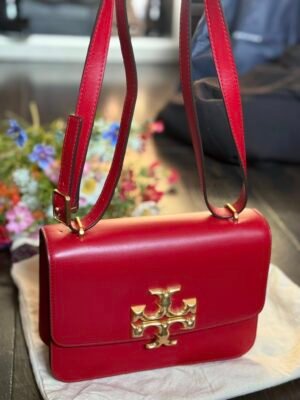 Красная кожаная сумка Tory Burch крупный план с золотой фурнитурой